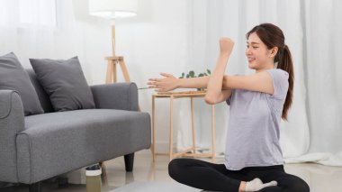 Yoga exercise concept, Young Asian woman stretching arms before workout with yoga training online.