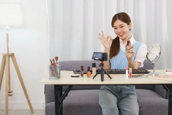 Beauty blogger concept, Young Asian woman recommend nail polish to subscribers in live streaming.
