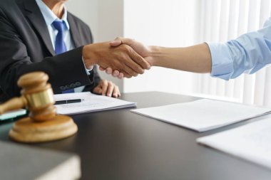 Lawyer and legal concept, Businessman and senior lawyer shake hands after successful deal contract.