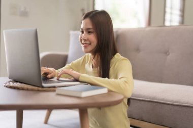 Relaxation concept, Young woman use laptop and typing on keyboard while sitting to relax on floor.