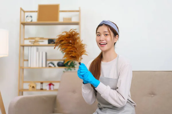 Hygiene cleaning concept, Housemaid is wear gloves and hold the feather duster to house cleaning.
