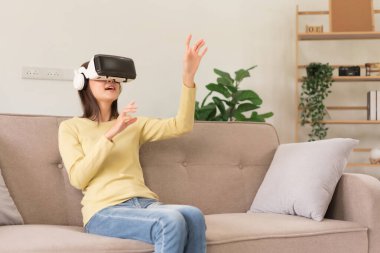 Leisure activities concept, Young woman touching the air to experience the virtual with glasses VR.
