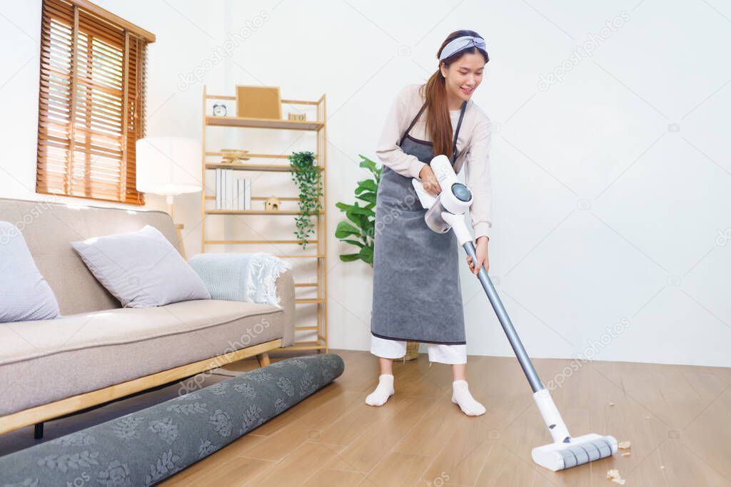 Housework concept, Housemaid use mop to mopping and cleaning dust on the floor in living room.