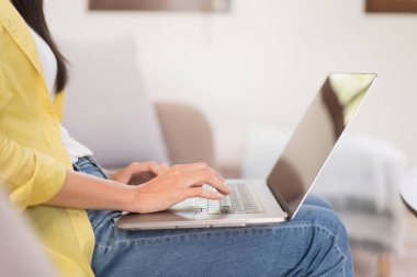 Relaxation concept, Young woman is chatting with friends on laptop while sitting on the couch.