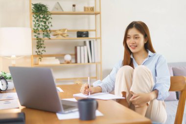 Uzak iş konsepti, iş kadını dizlerinin üstüne çöküp veri okuyup not alıyor..