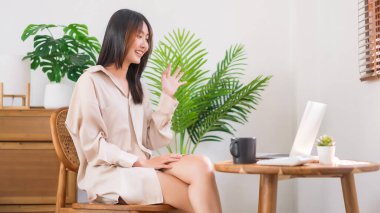 Oturma odasında faaliyet kavramı, Asyalı kadın arkadaşlarıyla selamlaşma jesti yapıyor..