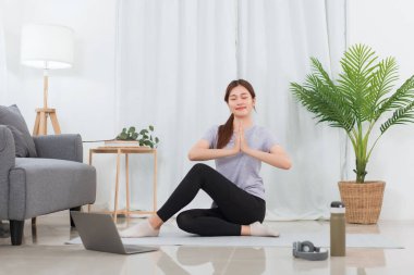 Yoga egzersizi konsepti, evde yoga yaparken nilüfer pozisyonunda genç Asyalı kadın..