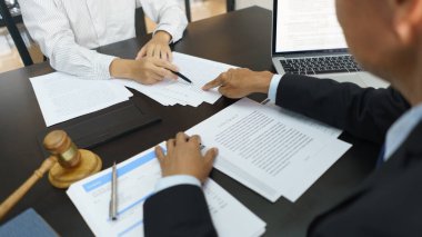 Lawyer and legal concept, Senior lawyer pointing to contract while explaining detail to businessman.