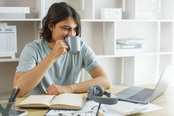 Distance education concept, Teen boy drinking coffee and studying lesson class online at home.