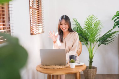 Ev konseptinde yaşam tarzı, videoda arkadaşıyla selamlaşma jesti yapan genç Asyalı kadın..