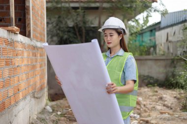 Mühendis konsepti. Beyaz maske takan ve miğfer takan kadın mühendis..