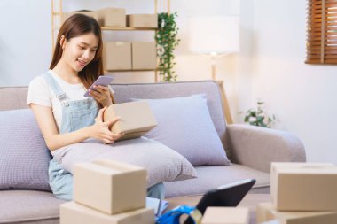 Online shopping concept, Female entrepreneur use smartphone to take picture parcel boxes to client.