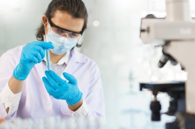 Laboratuvar araştırma konsepti, bilim adamı test tüpündeki numuneyi ilaç ve aşı geliştirmek için analiz ediyor..