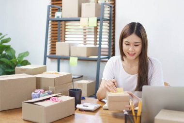 Çevrimiçi iş konsepti, Asyalı iş kadınları ürünü kontrol ediyor ve müşteriye teslimat için hazırlanıyor.