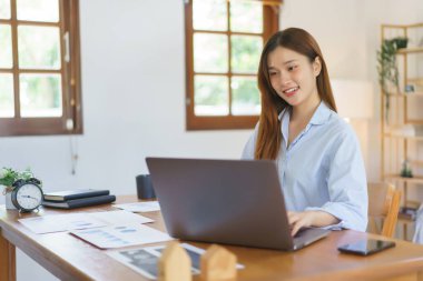 Uzak iş kavramı, İş kadını veri okumak ve pazarlama planı raporunu yazmak için dizüstü bilgisayar kullanıyor.