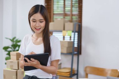 Çevrimiçi satış kavramı, Asyalı iş kadınları teslimatı hazırlamak için online siparişleri kontrol ediyorlar.