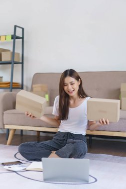 Çevrimiçi iş konsepti, Asyalı iş kadını müşteri için paket kutusunu göstermek için video görüşmesinde konuşuyor.