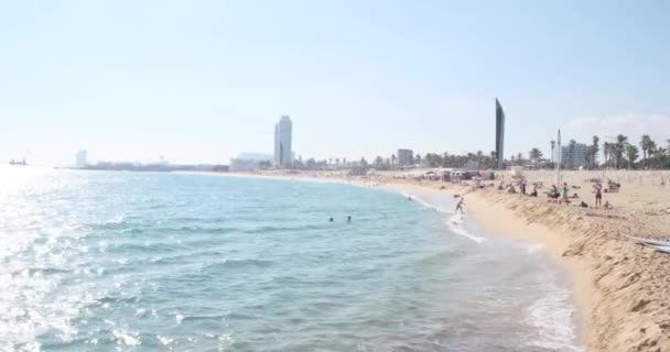 Barselona, İspanya - 2 Kasım 2021: Barcelona Sahili kıyısı, güneşli gün, mavi su ve dinlenen insanlar. Barceloneta Plajı, İllüstrasyon Editörü — Stok video