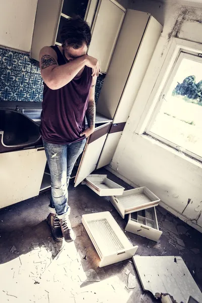 Exhausted punk rocker in messy house — Stock Photo, Image