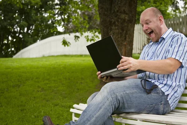 Glücklicher Mann, der in einem Park arbeitet — Stockfoto