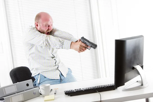 Boos zakenman bedreigt computer met een pistool — Stockfoto