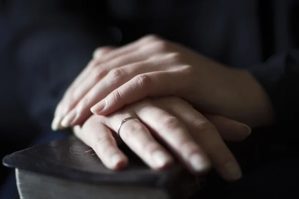 Mujeres sosteniendo las manos sobre una Biblia — Foto de Stock