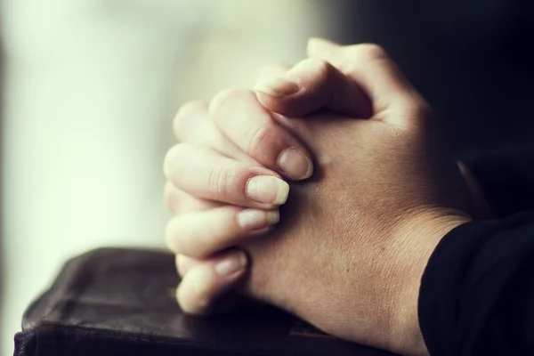 Składanie rąk w Biblii — Zdjęcie stockowe