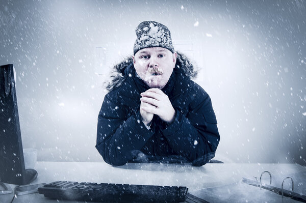 Бизнесмен в холодном офисе со снегом и льдом
