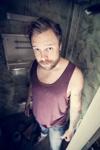 Punk rocker smokes cigarettes in dirty WC — Stock Photo, Image