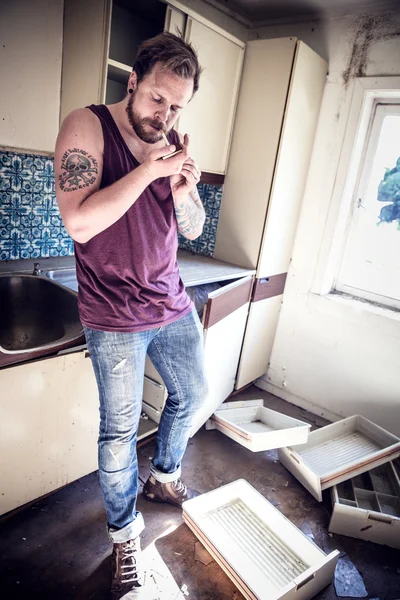 Punk rockero fuma en casa desordenada — Foto de Stock