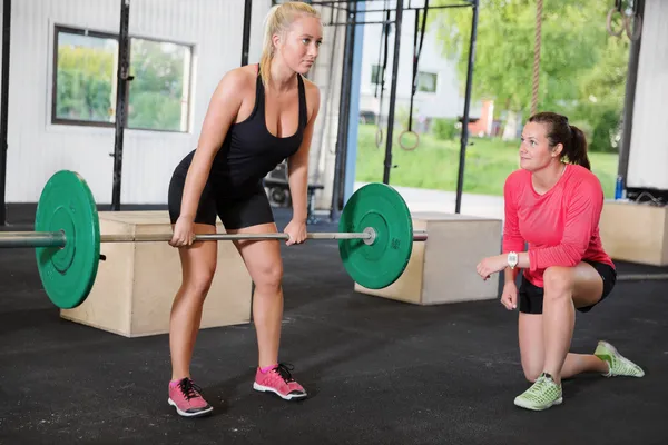 Crossfit woman lifts weights with personal trainer — Stock Photo, Image