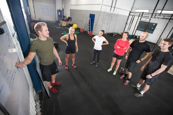 Personal trainer teaches his fitness workout team — Stock Photo, Image