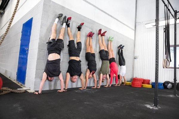 Team exercising handstands at fitness gym center — Stock Photo, Image