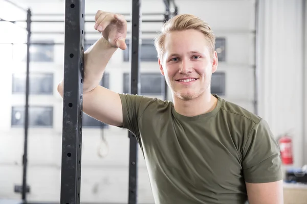 Lächelnder Mann ruht sich im Fitnessstudio aus — Stockfoto