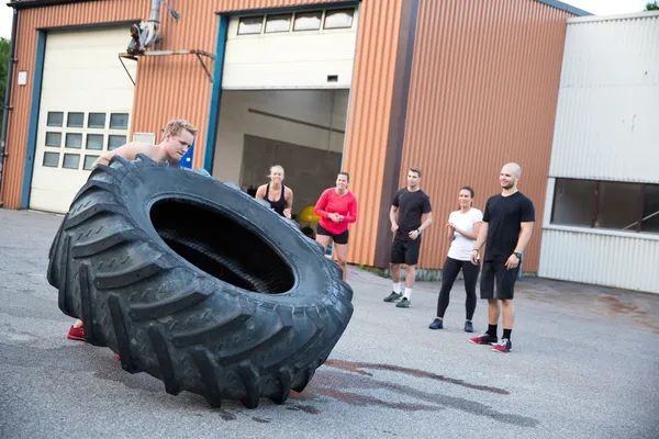 Hombre voltear neumáticos pesados al aire libre como entrenamiento —  Fotos de Stock