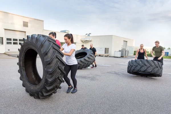 Equipo de fitness volteando neumáticos pesados como entrenamiento — Foto de Stock