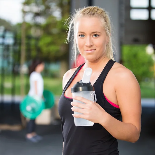 Donna riposo e acqua potabile dopo l'allenamento — Foto Stock