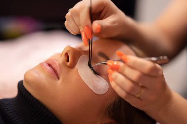 Sahte kirpikler takmak için cımbız kullanan Uzmanların Elleri