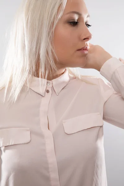 Belle blonde modèle féminin en chemise tenant ses cheveux et détournant les yeux — Photo
