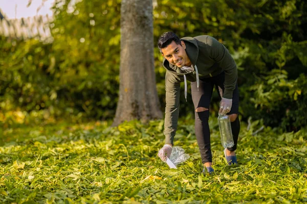 Lächelnd und engagiert säubern Ehrenamtliche Müll auf Gras in der Natur — Stockfoto