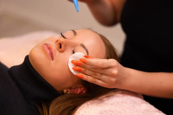 Hands Of Beauty Specialist pocieranie bawełny na kobiecych klientów twarzy — Zdjęcie stockowe