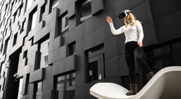 環境現代の未来的な建物に対して仮想現実技術を身に着けているブロンドの女性の肖像画 乱暴なビジネスでの買い物 — ストック写真