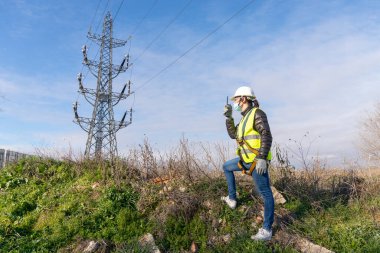 KADIN YÜKSEK Yelekle, YÜKSEK, HELMET, HARNESS, GİZLERİ, VE KADIN GÖREVLERİNDE ÇALIŞIYOR