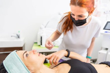 Hasta, teknisyene lazer yüz tedavisinin detaylarını anlatıyor.