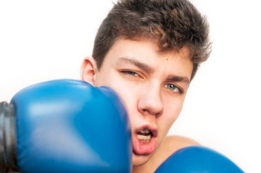 Beyaz bir arka planda boks eldiveniyle bir gencin suratına tekme yemişti. Komik kıvrık bir yüzü var. Diş telleri dişlerine takılı.