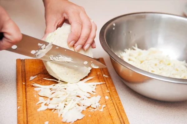 Woman at home cut cabbage with a great salad knife. A woman makes a salad for her family for dinner