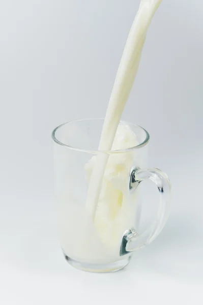 Genomskinligt glas med hälla mjölk i det — Stockfoto