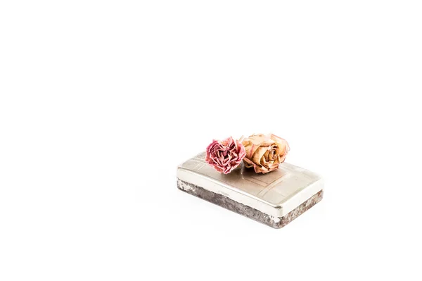 Oude roestige tabak doos met rozen bovenop — Stockfoto