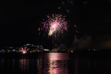 Bacoli, Napoli, 9 Ağustos 2022. Havai fişekler gökyüzünü çeşitli renklerle boyuyor ve Miseno Gölü 'ne yansıtılarak nefes kesici bir manzara yaratıyor..