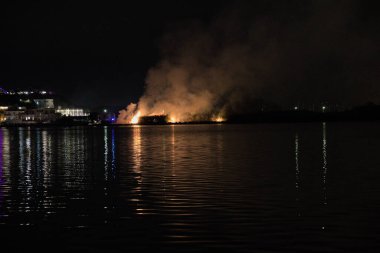 Bacoli, Napoli, 9 Ağustos 2022. Gölün kıyısında yangın, bir sürü bitki yakma..